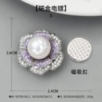 High-end magnetic camellia CZ pearl brooch wholesale featuring micro-pave white and purple cubic zirconia petals, a luminous glass pearl center, and a strong pinless magnetic back clasp in gold or rhodium finish from junejewelry.com