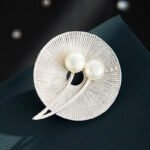 Pearl round brooch wholesale featuring a textured radial disc design adorned with dual freshwater pearls and sparkling cubic zirconia stones from junejewelry.com