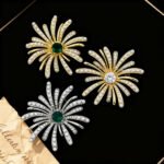 Dazzling firework pearl crystal brooch wholesale featuring radiating metallic rays set with round pearls and pave cubic zirconia centered around a brilliant jewel gemstone, with convertible pendant hook functionality from junejewelry.com