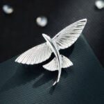 Minimalist 3D flying fish brooch wholesale featuring a textured metal winged fish design in high-shine silver or gold finish from junejewelry.com