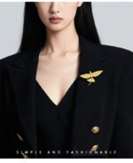 Minimalist 3D flying fish brooch wholesale featuring a textured metal winged fish design in high-shine silver or gold finish from junejewelry.com
