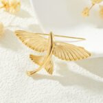 Minimalist 3D flying fish brooch wholesale featuring a textured metal winged fish design in high-shine silver or gold finish from junejewelry.com