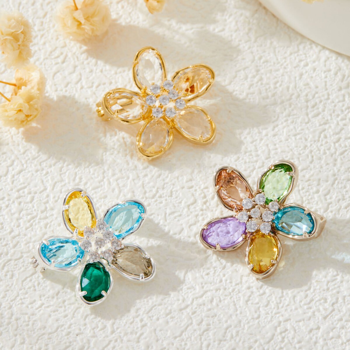 Colorful five-petal flower brooch pin wholesale featuring oval-cut cubic zirconia crystal petals with a micro-pave CZ centerpiece from junejewelry.com