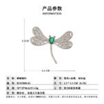 Dragonfly brooch wholesale featuring openwork filigree wings set with clear cubic zirconia, an oval gemstone body, and green CZ eyes from junejewelry.com