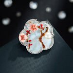 Oriental vintage Chinese style mother of pearl plum blossom brooch wholesale featuring a scalloped natural white shell base overlaid with pink enamel plum blossoms, branches, and a freshwater pearl in gold or silver finish from junejewelry.com