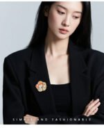 Oriental vintage Chinese style mother of pearl plum blossom brooch wholesale featuring a scalloped natural white shell base overlaid with pink enamel plum blossoms, branches, and a freshwater pearl in gold or silver finish from junejewelry.com