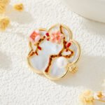 Oriental vintage Chinese style mother of pearl plum blossom brooch wholesale featuring a scalloped natural white shell base overlaid with pink enamel plum blossoms, branches, and a freshwater pearl in gold or silver finish from junejewelry.com