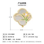 Vintage style four leaf clover mother of pearl orchid brooch wholesale featuring a natural white mother of pearl clover base overlaid with green enamel orchid leaves and a freshwater pearl flower center in gold or silver finish from junejewelry.com