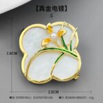 Vintage style four leaf clover mother of pearl orchid brooch wholesale featuring a natural white mother of pearl clover base overlaid with green enamel orchid leaves and a freshwater pearl flower center in gold or silver finish from junejewelry.com