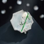 Oriental vintage Chinese style mother of pearl bamboo brooch wholesale featuring a scalloped natural white shell base overlaid with green enamel bamboo stalk, leaves, cubic zirconia accent, and freshwater pearl in gold or silver finish from junejewelry.com