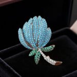 High-end turquoise protea flower CZ brooch wholesale featuring pave turquoise stone petals, green cubic zirconia leaves, and a clear pave crystal stem from junejewelry.com