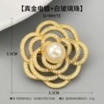 Elegant camellia flower pearl brooch wholesale featuring layered hollow micro-pave cubic zirconia petals centered with a round gray, white, or champagne glass pearl from junejewelry.com