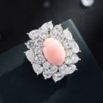 Light luxury pink queen conch shell magnetic brooch wholesale featuring an oval pink shell center surrounded by brilliant round and pear-cut cubic zirconia crystals with a strong magnetic clasp from junejewelry.com