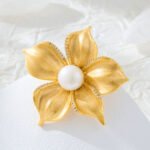 Vintage brushed gold flower pearl brooch wholesale featuring wire-brushed matte gold petals, micro-pave cubic zirconia edges, and a large central white freshwater pearl from junejewelry.com