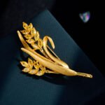 Elegant golden wheat ear CZ brooch wholesale featuring brushed matte gold leaves and marquise-cut yellow cubic zirconia wheat grains on a gold-plated setting from junejewelry.com