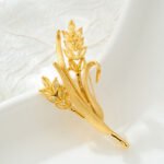 Elegant golden wheat ear CZ brooch wholesale featuring brushed matte gold leaves and marquise-cut yellow cubic zirconia wheat grains on a gold-plated setting from junejewelry.com