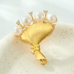 Light luxury brushed sand gold bouquet pearl brooch wholesale featuring wire-brushed matte gold wrapping, freshwater pearl blooms, and sparkling CZ accents from junejewelry.com