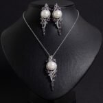 Niche pearl crystal vine jewelry set wholesale featuring a lustrous synthetic pearl encircled by an asymmetric marquise crystal vine motif with matching drop earrings from junejewelry.com