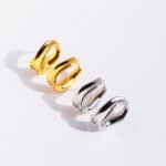 Wholesale modern sculptural twisted wave huggie hoop earrings with genuine 18K gold and white gold plating on copper