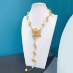 Shell pearl floral necklace wholesale featuring 18k gold plated dual chain strand with station shell pearls, 3D micro pave cz lily flower adjustable slide clasp, and dangling tassel ends.