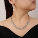 Floral crystal jewelry set wholesale featuring continuous four-petal flower stations necklace with sparkling marquise crystals and matching teardrop dangle earrings on palladium plated copper.