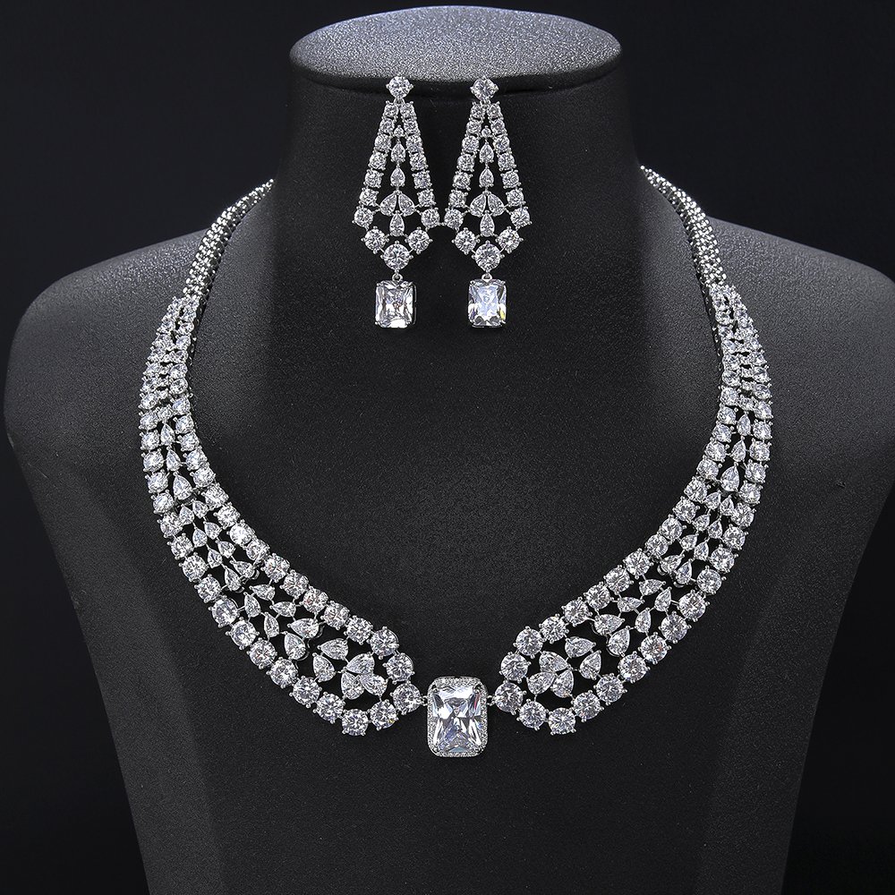 Emerald Cut Crystal Jewelry set wholesale featuring triple-row pave crystal lattice collar necklace centered with radiant emerald cut halo gem and matching drop earrings on palladium plated copper.