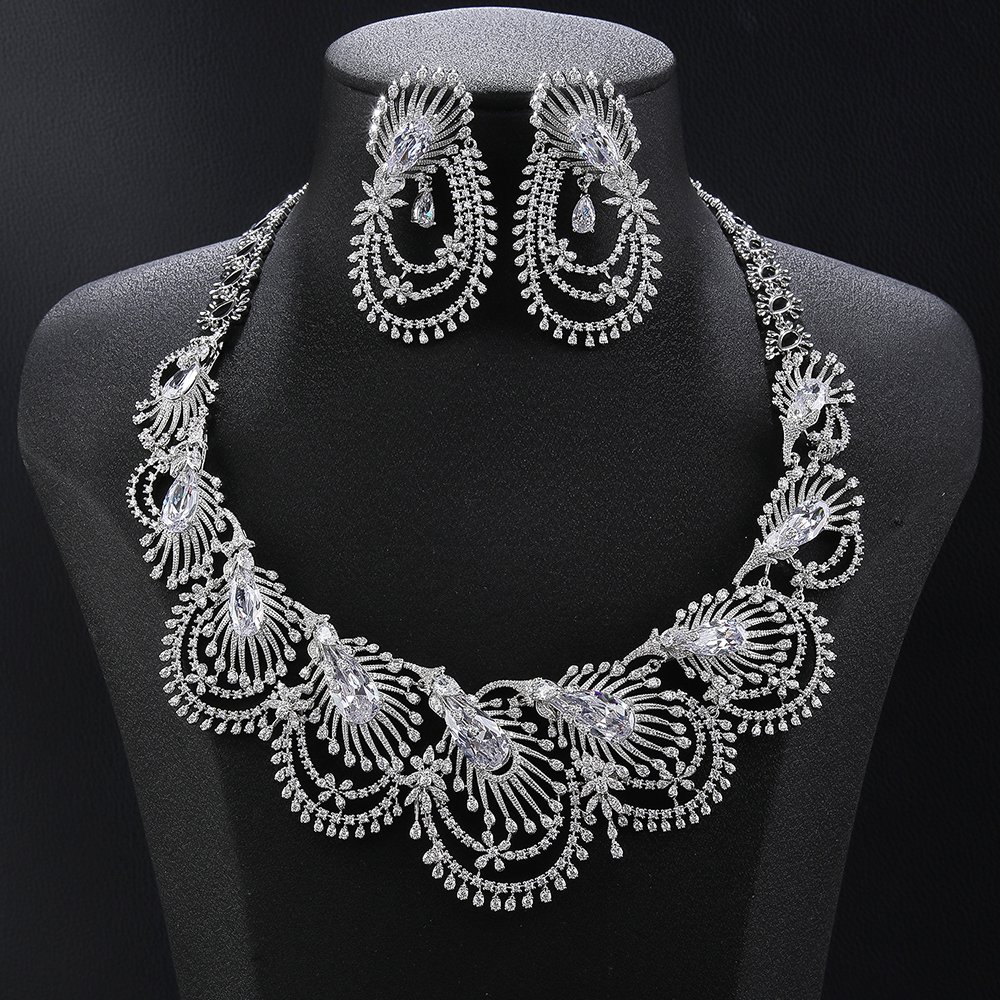 Peacock crystal jewelry set wholesale featuring radial peacock feather fan collar necklace with marquise cut main crystals, layered arc drop fringe, and matching dangle earrings on palladium plated copper.