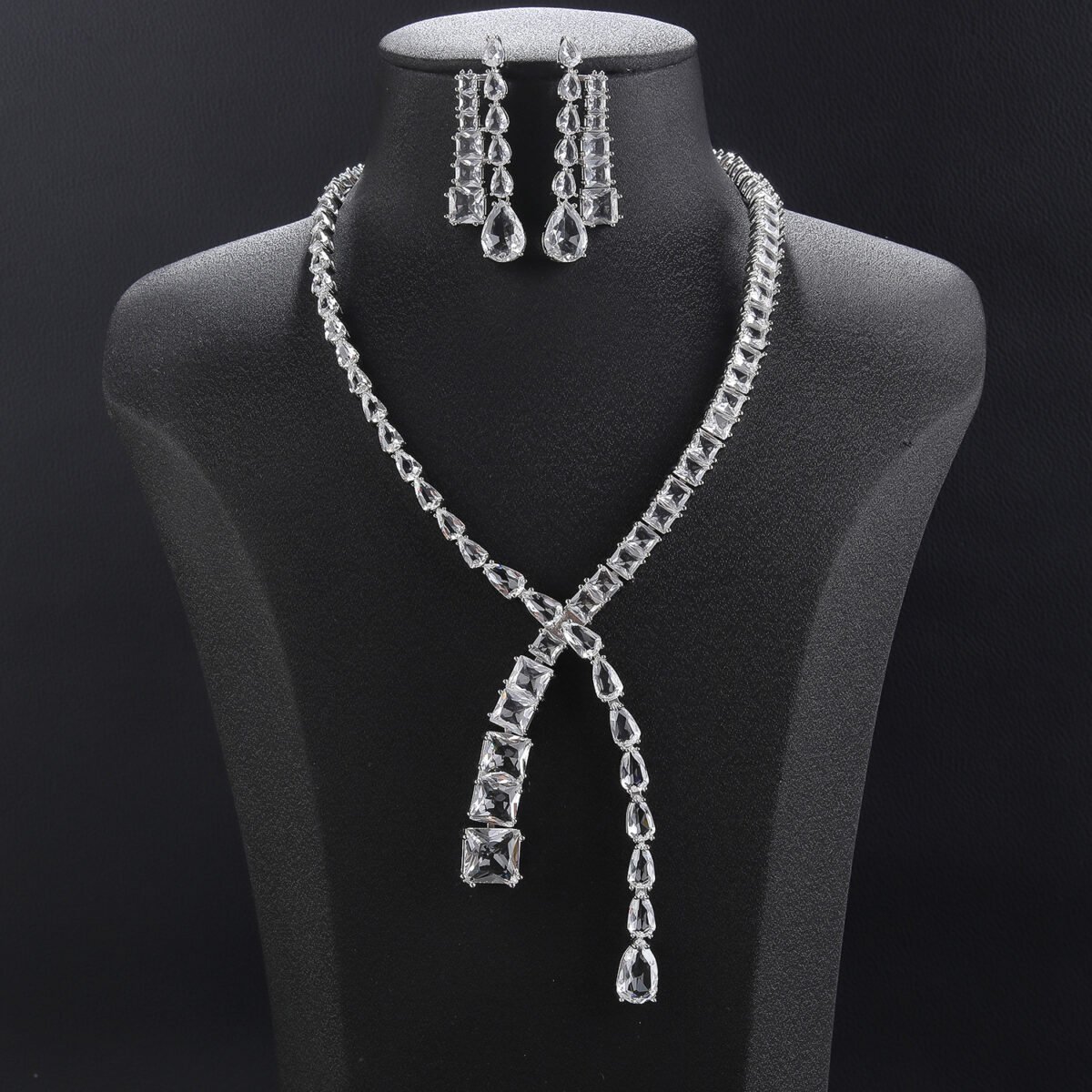 Y lariat crystal jewelry set wholesale featuring asymmetric emerald cut and pear cut crystal lariat necklace with dangling stream drop and matching earrings on palladium plated copper.