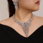 Rose blossom crystal jewelry set wholesale featuring 3D pave crystal dual rose flowers with dangling triangular leaf cluster pendant and matching drop earrings on palladium plated copper base.