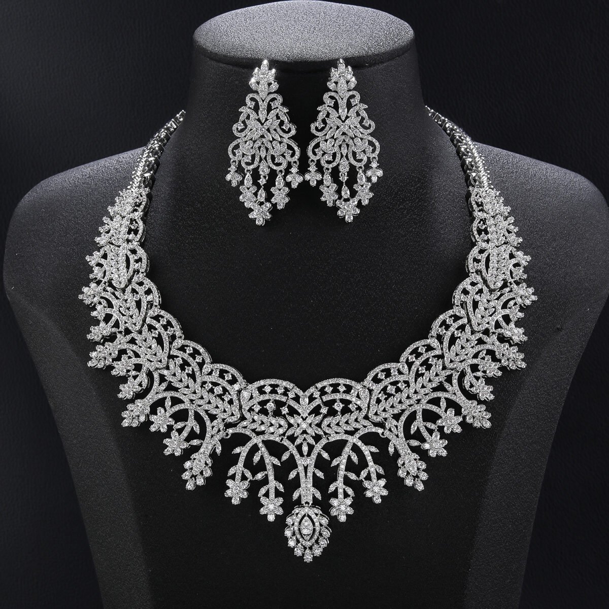 Crown lace crystal jewelry set wholesale featuring regal tiara arch openwork collar necklace with branching floral tassels and matching chandelier earrings on palladium plated copper.