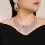 Crown lace crystal jewelry set wholesale featuring regal tiara arch openwork collar necklace with branching floral tassels and matching chandelier earrings on palladium plated copper.