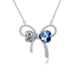 Silver bow pendant necklace with pavé ribbons, heart-shaped crystal, and multi-colored pave accents wholesale