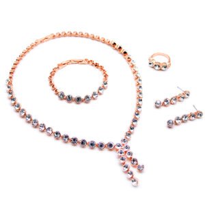 Wholesale crystal drop jewelry set featuring clear round premium crystals, lariat necklace, drop earrings, tennis bracelet, and ring on 18K gold-plated copper base from JuneJewelry.com.