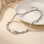 Gold and silver plated chunky irregular pebble bead strand necklace with a center pearl in ore material metal