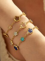 Gold plated stainless steel jewelry set featuring alternating crystal pave flowers and faceted glass five-petal flower motifs