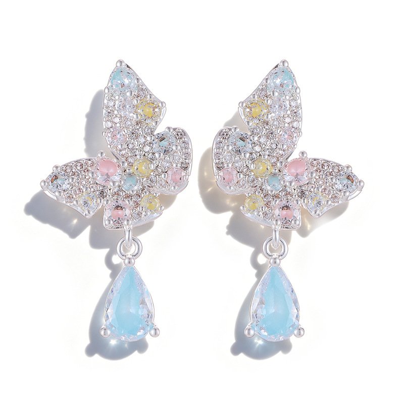 Pastel butterfly crystal earrings wholesale featuring pave cubic zirconia butterfly posts with dangling ice blue and soft pink teardrop crystal drops on palladium plated copper base.