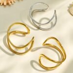 Gold and silver plated 316L stainless steel open cuff bangle with a fluid double-line wavy organic design