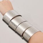 Polished 18K gold plated and silver stainless steel wide open cuff bangles with laser etched geometric honeycomb, clover, wave, and floral patterns