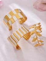Two tone 18K gold plated and enamel white silver stainless steel open cuff bangles featuring leaf, wave, and multi-band hammered textures