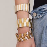 Two tone 18K gold plated and enamel white silver stainless steel open cuff bangles featuring leaf, wave, and multi-band hammered textures
